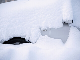 Side view of car completely covered by snow.