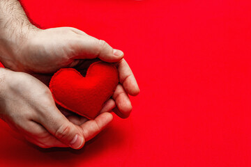 Fototapeta premium Male hands are holding a homemade felt heart