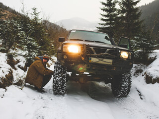 Off-road car trip through the Ukrainian Carpathians in winter. Christmas trees and snowy road. External expedition.Wheel
