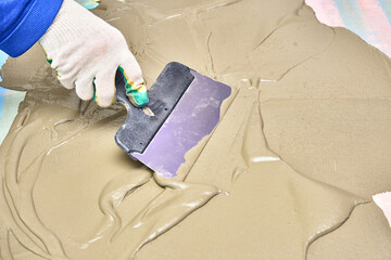 worker in gloves puts plaster with spatula. repair, construction
