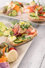 Quick and healthy recipes. Salad with salmon, vegetables and herbs on Italian ciabatta bread. Vertical shot