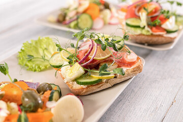 Quick and healthy food recipes. Salad with salmon, vegetables and herbs on Italian ciabatta bread. Mediterranean dish recipes. Selective focus.