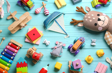 Different toys on light blue wooden background, flat lay