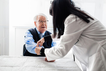 Nurse drawing blood from an elderly man in his home. Home care.