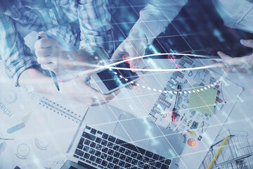 Double exposure of forex graph drawing and man and woman working together holding and using a mobile device. Trade concept.