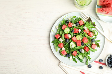 Delicious salad with watermelon served on white table, flat lay. Space for text
