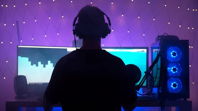 RGB gamer computer and person silhouette listening to music 4K