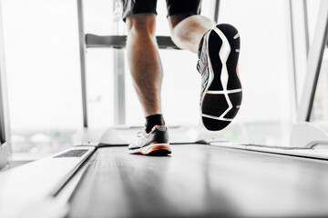 Naklejka na ściany i meble Close up photo of male feet on a treadmill. Cardio