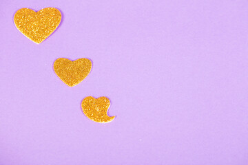 beautiful yellow hearts on a purple background, love concept, top view close up