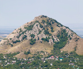 Beautiful mountain scenery. Mountains covered with green trees with residential settlements. In...