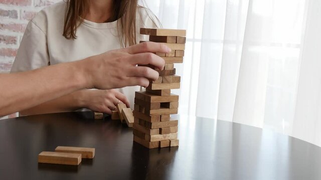 A woman and a man are playing Jenga. Table games. Family vacation and holidays concept.