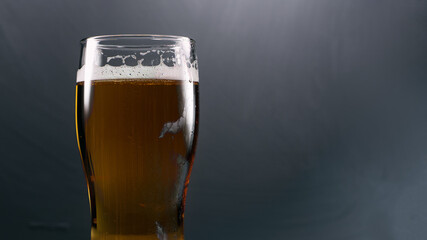 Cold glass of light beer close-up on concrete background