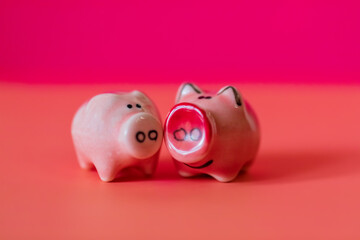 Two little pigs on a pink background. Composition for Valentine's Day. Finance concept. Piggy bank, animals, figurines. Copy space, top view.