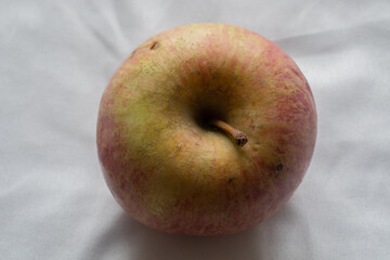 Apple on a white surface. Red-green apple on a white surface