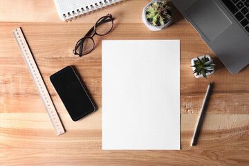 Flat lay composition with blank paper sheet on wooden background. Space for text