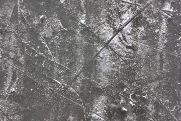 Gray ice rink texture with snow and skate marks. Frozen river abstract background. Scratched ice surface. 