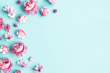 Flowers composition. Pink flowers on pastel blue background. Flat lay, top view
