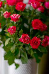 A bouquet of red little roses in a silver vase