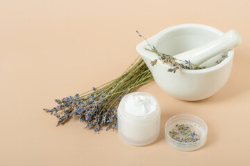 Obraz na płótnie Canvas body cream with lavender on a beige background.