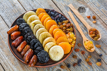 Different dried fruits on a plate on a wooden table