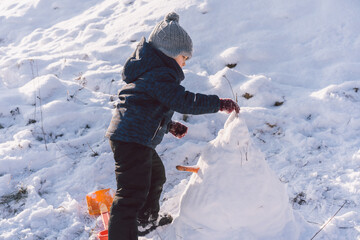 Little boy playing with snow. Winter holiday. 