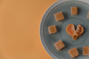 heart shaped malmalade and dried mandarin, on a yellow background. Top view