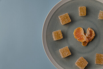 heart shaped malmalade and dried mandarin, on a blue background. Top view