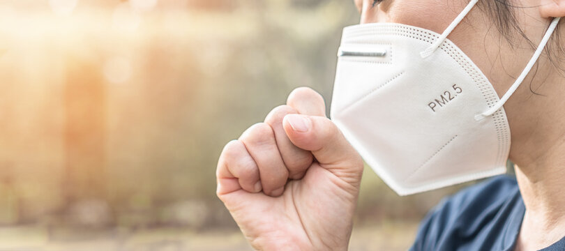 PM2.5 protection KN95 face mask with filter prevention from air pollution, respiratory lung disease and health safety awareness with sneezing or coughing woman from PM 2.5 allegic illness