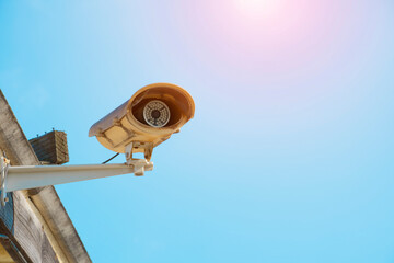 Electronic CCTV camera security system.Installed on the roof on sky blue background.