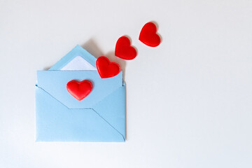 Love letter, blue envelope and flying red hearts