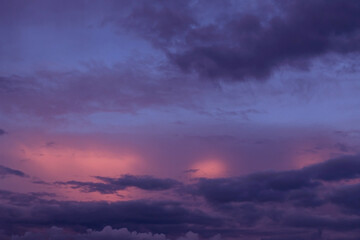 Sunrise, sunset pink violet blue sky with dark storm clouds background texture	
