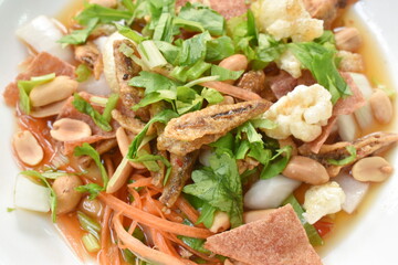 crispy fish with pork couple maw topping peanut in spicy and sour chili sauce salad on plate