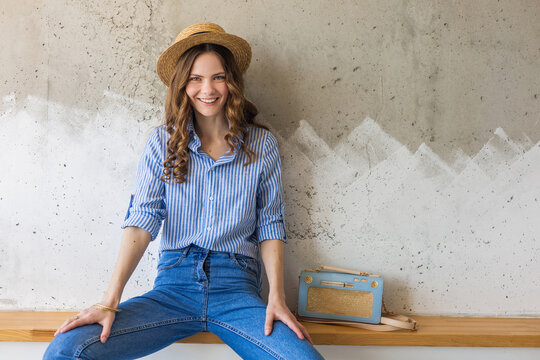 portrait of young pretty woman with straw hat jeans blue cotton shirt