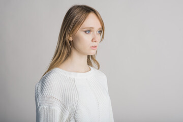 Fototapeta premium Portrait of a beautiful girl on a white background in the studio with a place for writing text