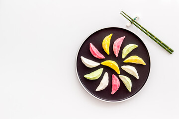 Chinese colourful steamed dumplings on black plate, top view