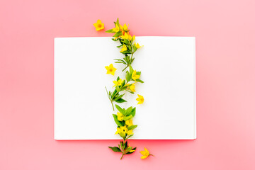 White paper blank with yellow spring flowers, overhead view