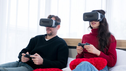 Couple playing video game with virtual reality goggles at home