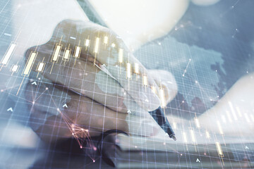 Abstract creative financial graph with world map and with woman hand writing in notebook on background, forex and investment concept. Multiexposure