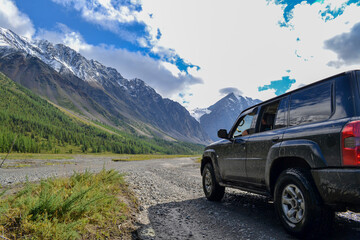 Obraz na płótnie Canvas Off-road SUV car with Aktru mountain valley and glacier background. Adventure travel concept. Adventure tourism. Nature landscape. Overland 4x4 journey concept.