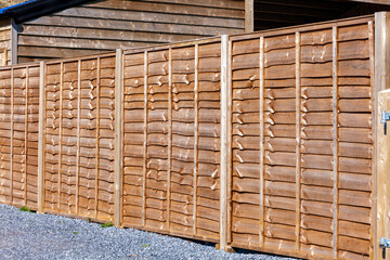 New wooden residential back yard garden fence which is usually made of pine or larch wood, stock photo image