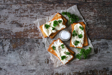 Soft focus. Salty crackers with white cream cheese.