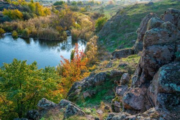 Beautiful small river among large stones and green vegetation on the hills in Ukraine