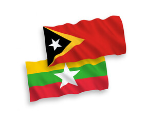 National vector fabric wave flags of East Timor and Myanmar isolated on white background. 1 to 2 proportion.