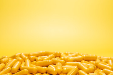 Yellow capsule drug with blank copy space on yellow background. 