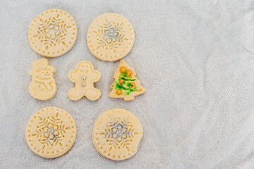 Traditional almond cookie with sugar, spices, and vintage rolling pin on rustic, on natural linen background.