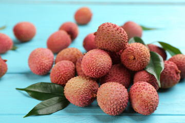 Fresh ripe lychee fruits on light blue wooden table