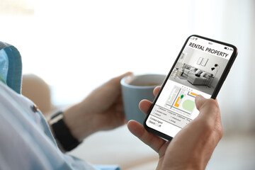 Man searching for apartment on rental property website via smartphone, closeup