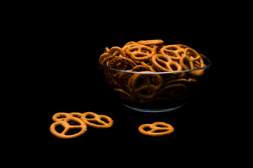 Brezel cookies in glass bowl on dark background
