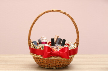 Fototapeta na wymiar Wicker gift basket with cosmetic products on wooden table