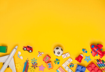 Frame of kids toys on yellow background with copyspace